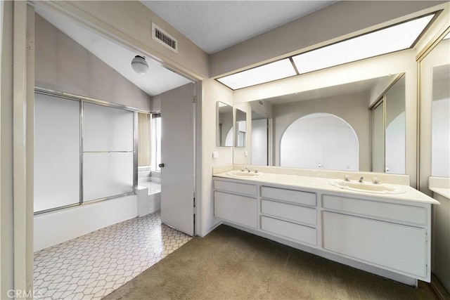 bathroom featuring vanity, vaulted ceiling, and enclosed tub / shower combo