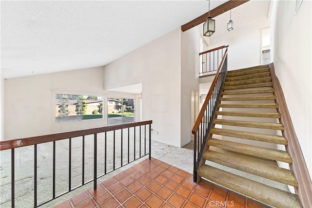 staircase with tile patterned floors and vaulted ceiling