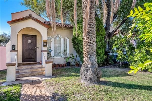 view of exterior entry with a yard