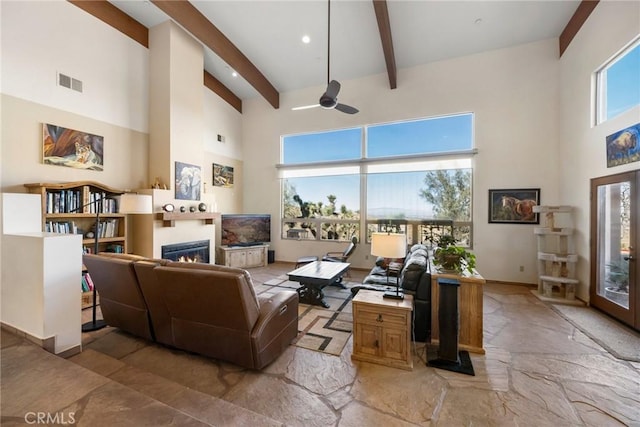 living room with beamed ceiling and a high ceiling