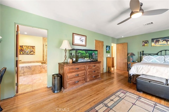 bedroom with light hardwood / wood-style floors, connected bathroom, and ceiling fan