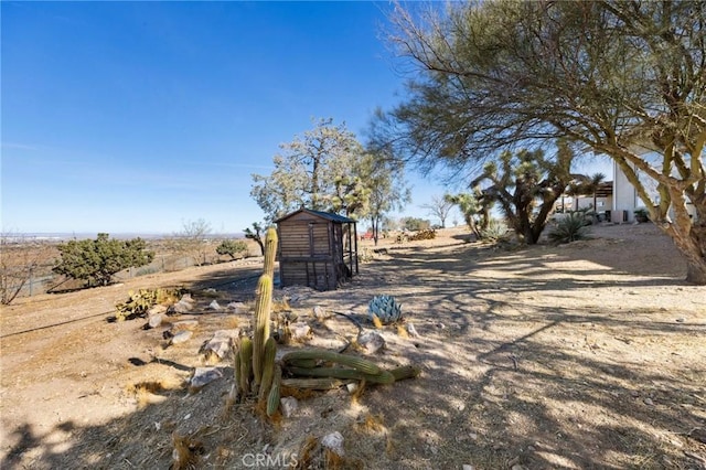 view of yard with a storage shed and a rural view