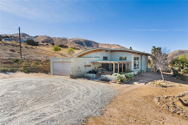 view of front facade with a porch, a garage, and a mountain view