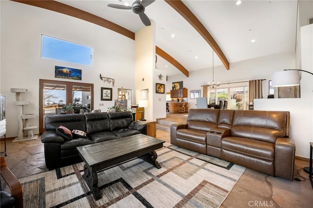 living room with a towering ceiling, french doors, beamed ceiling, and ceiling fan with notable chandelier