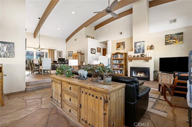 living room featuring ceiling fan with notable chandelier, high vaulted ceiling, and beamed ceiling