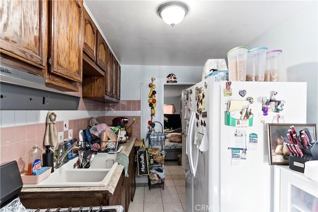 kitchen with white fridge with ice dispenser, tasteful backsplash, and light tile patterned flooring