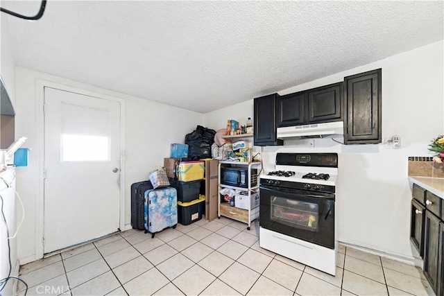 kitchen featuring light tile patterned floors, a textured ceiling, and white gas range oven