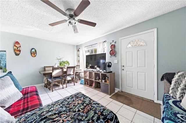 tiled living room featuring ceiling fan and a textured ceiling