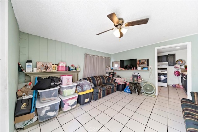 tiled living room featuring ceiling fan and a textured ceiling