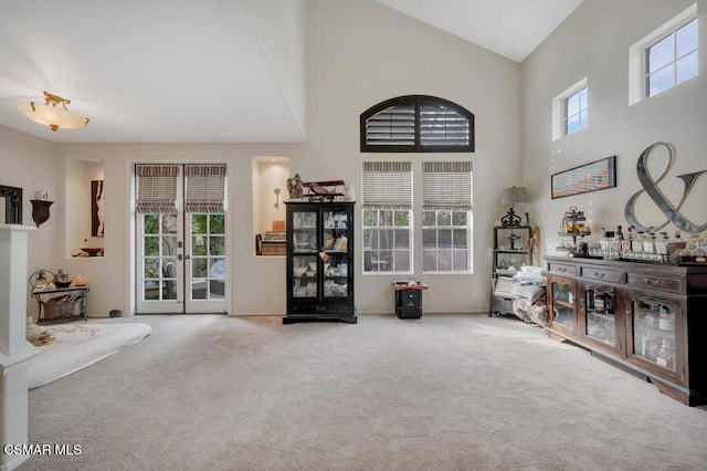 miscellaneous room with a towering ceiling, french doors, a healthy amount of sunlight, and carpet flooring