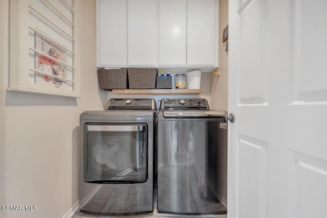 washroom featuring cabinets and washing machine and clothes dryer