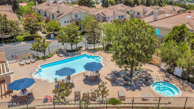 view of swimming pool featuring a jacuzzi and a patio