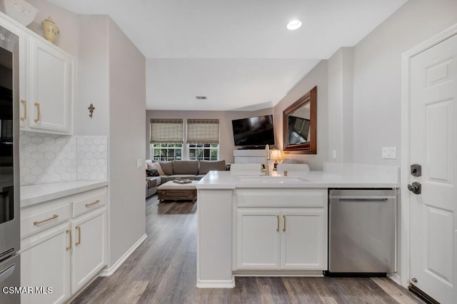 kitchen featuring decorative backsplash, sink, white cabinetry, and stainless steel dishwasher