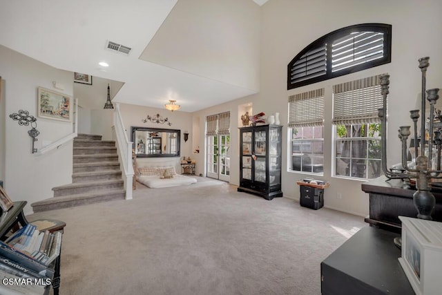 carpeted living room with a high ceiling