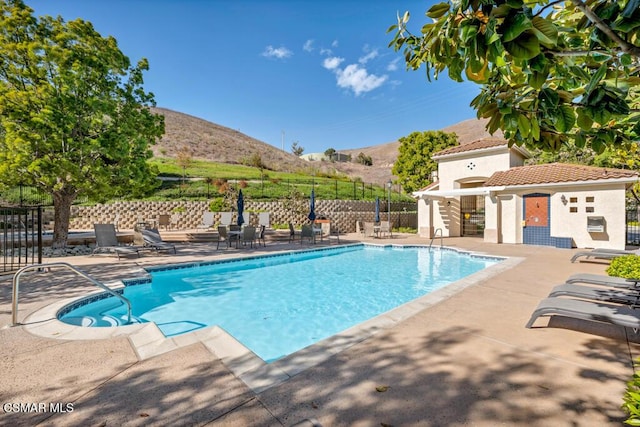 view of swimming pool with a mountain view and a patio area