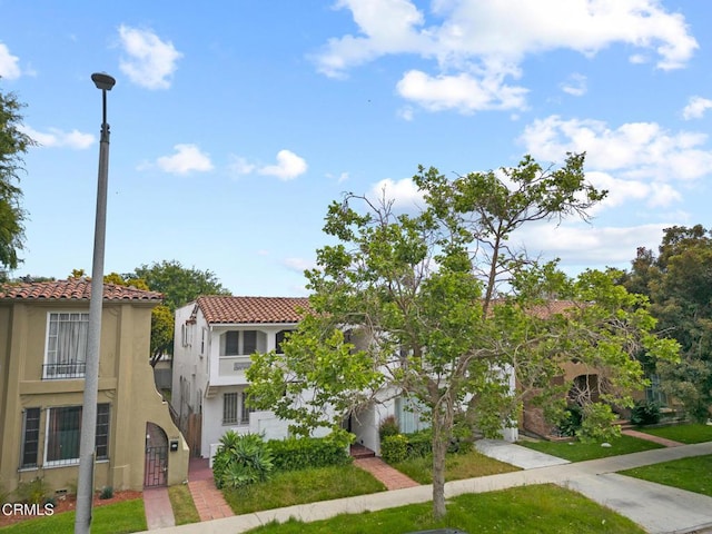view of front of house featuring stucco siding and a tile roof