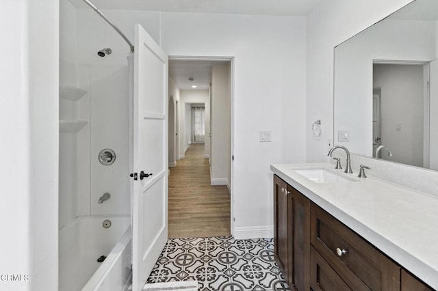 full bath featuring baseboards, tile patterned flooring, vanity, and shower / washtub combination