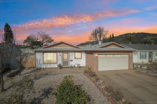 ranch-style house featuring a garage and a mountain view