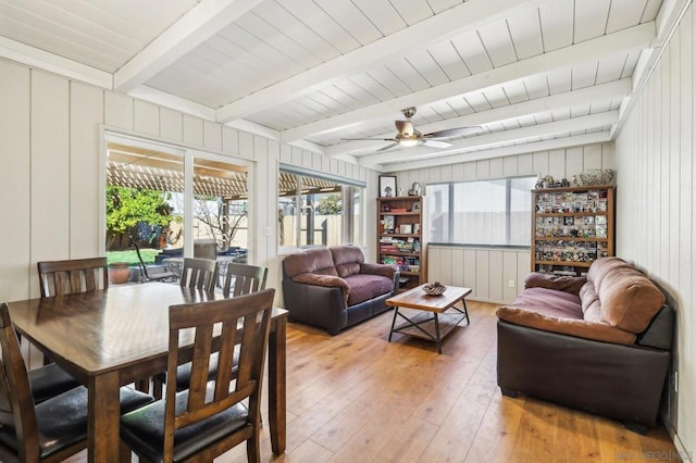 sunroom with ceiling fan and beam ceiling