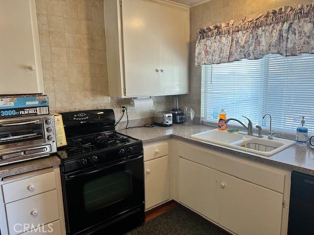 kitchen with a sink, a toaster, black appliances, and white cabinetry