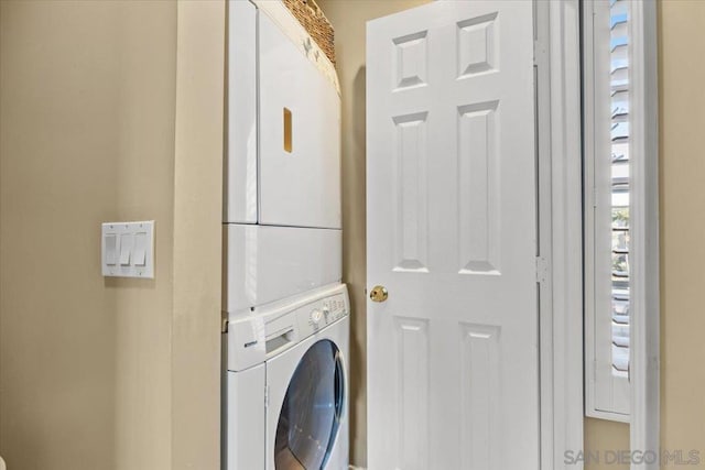 clothes washing area with stacked washing maching and dryer