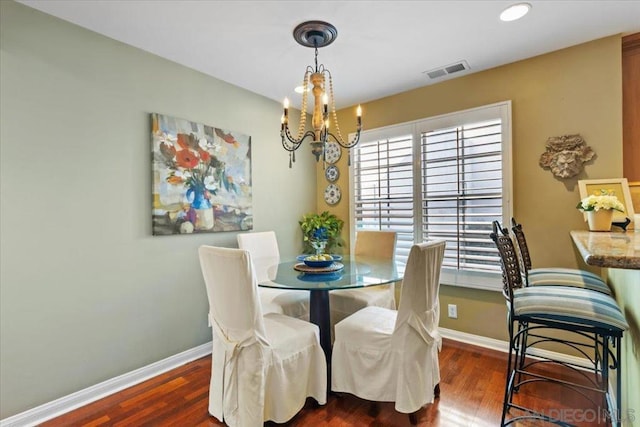 dining room featuring dark hardwood / wood-style flooring and a chandelier