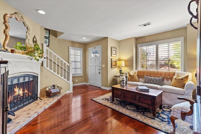 living room featuring hardwood / wood-style floors and a tiled fireplace