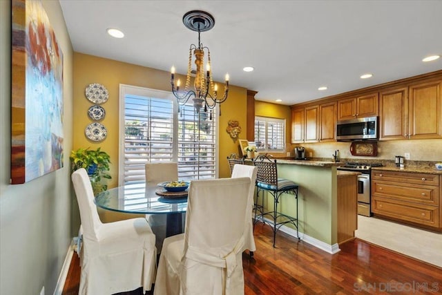 dining area with a chandelier and dark hardwood / wood-style floors