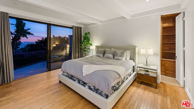 bedroom featuring hardwood / wood-style floors and beam ceiling