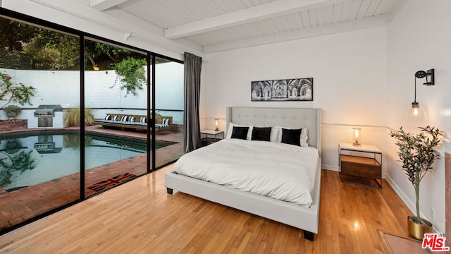 bedroom featuring beam ceiling, access to outside, and hardwood / wood-style floors