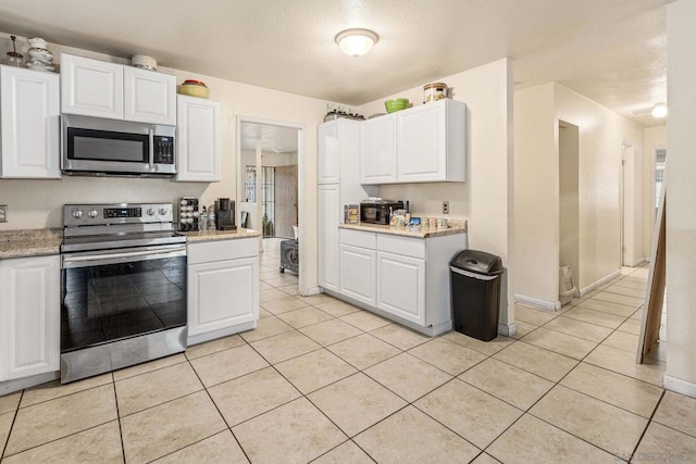 kitchen with white cabinetry, light tile patterned floors, and appliances with stainless steel finishes