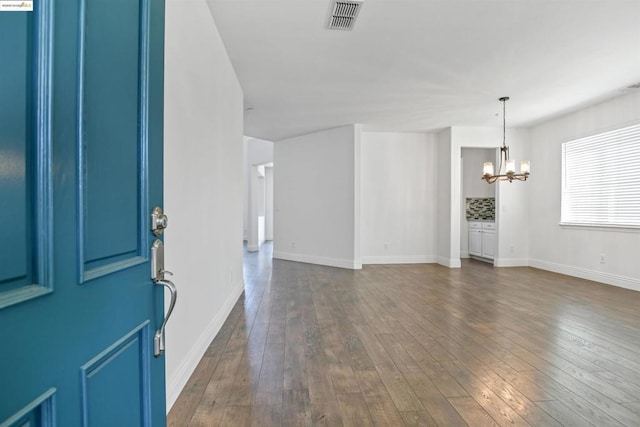 foyer entrance featuring dark wood-type flooring and a notable chandelier