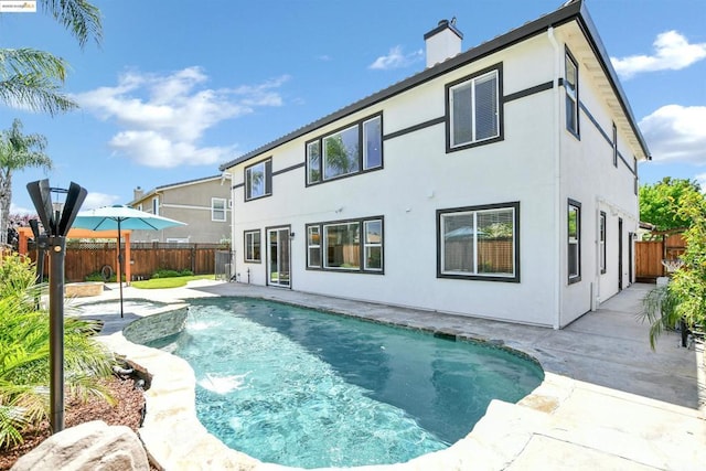 back of house featuring a fenced in pool, a patio area, and pool water feature