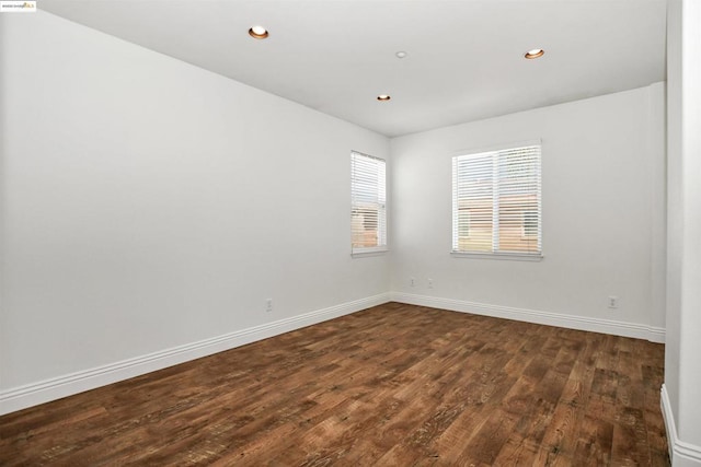 unfurnished room with dark hardwood / wood-style flooring