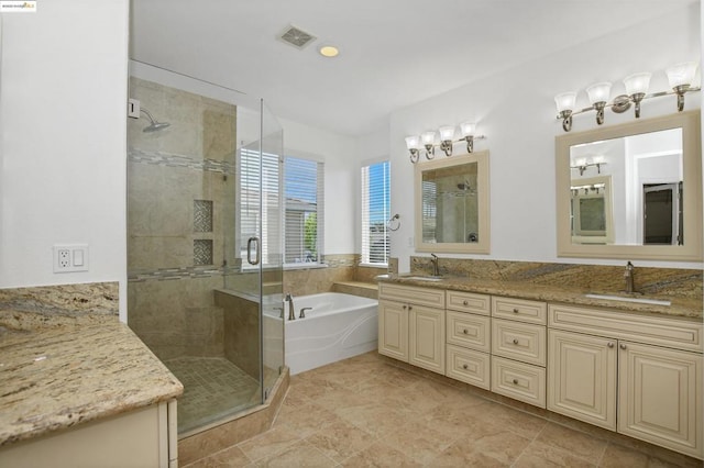 bathroom featuring vanity and independent shower and bath