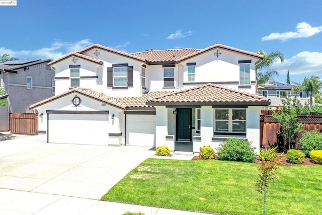 mediterranean / spanish house featuring a garage and a front yard