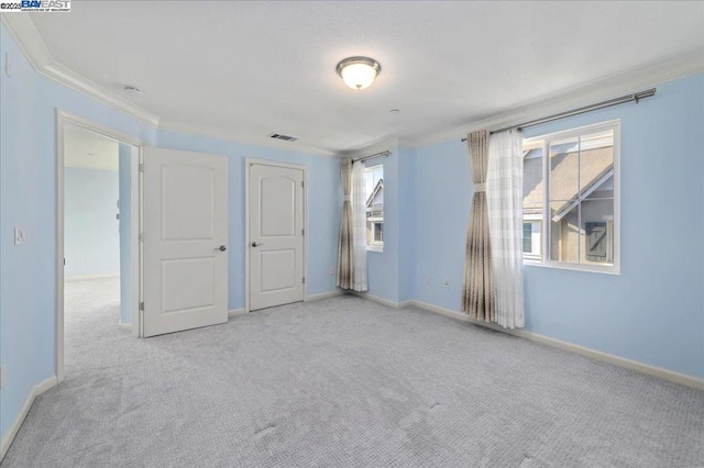 unfurnished bedroom featuring ornamental molding and light carpet