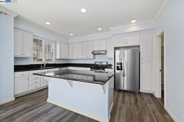 kitchen featuring dark wood-type flooring, white cabinetry, a breakfast bar, a kitchen island, and stainless steel appliances