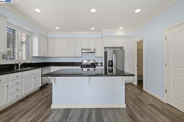 kitchen featuring a center island, appliances with stainless steel finishes, white cabinetry, sink, and dark wood-type flooring