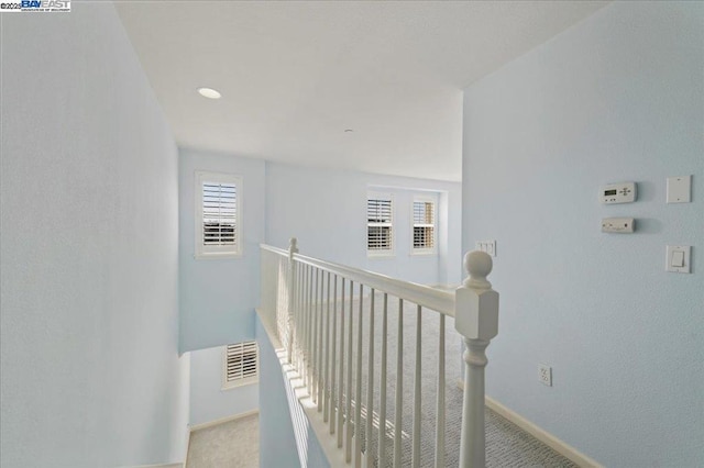 hallway featuring light colored carpet