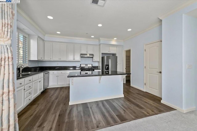 kitchen with a kitchen island, white cabinets, and stainless steel appliances