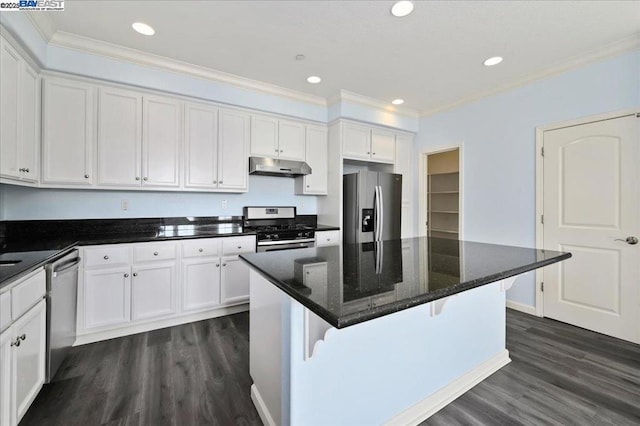 kitchen featuring white cabinets, appliances with stainless steel finishes, a center island, dark wood-type flooring, and dark stone countertops