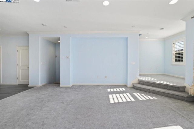 spare room with dark colored carpet and ornamental molding