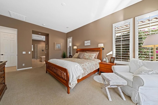 bedroom featuring light colored carpet and connected bathroom