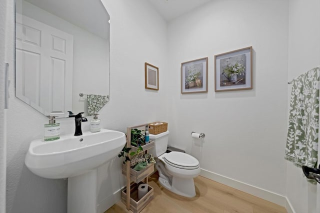 bathroom featuring wood-type flooring, toilet, and sink