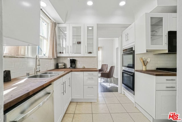 kitchen with sink, white cabinetry, black appliances, and wood counters