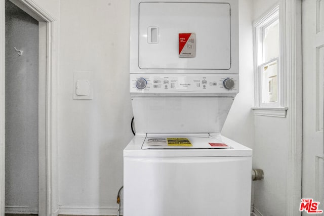 washroom featuring stacked washer and clothes dryer