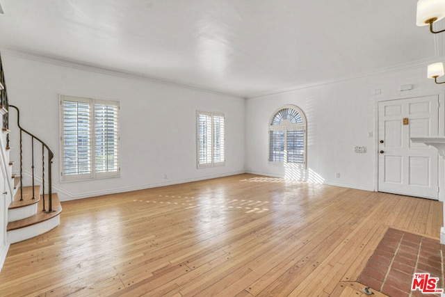 unfurnished living room featuring light wood-type flooring, a wealth of natural light, and crown molding