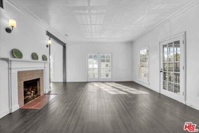 unfurnished living room with dark wood-type flooring, a brick fireplace, and ornamental molding