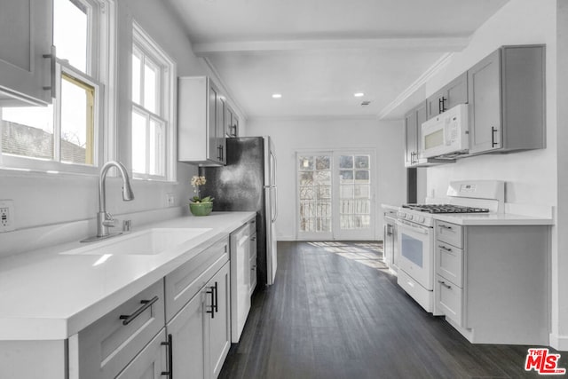 kitchen featuring white appliances, sink, dark hardwood / wood-style floors, gray cabinets, and beam ceiling